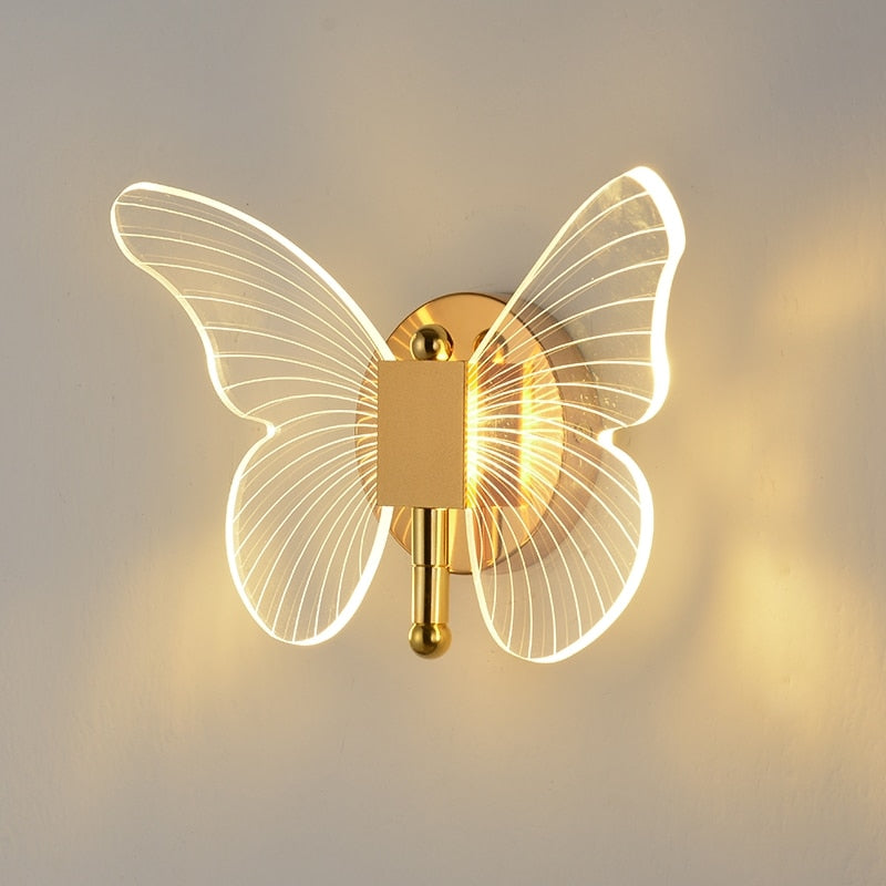 Acrylic wall lamp in the shape of a butterfly emitting a warm white glow against a neutral backdrop