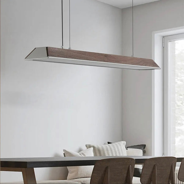 Modern walnut wood suspension linear pendant light hanging elegantly above a dining table